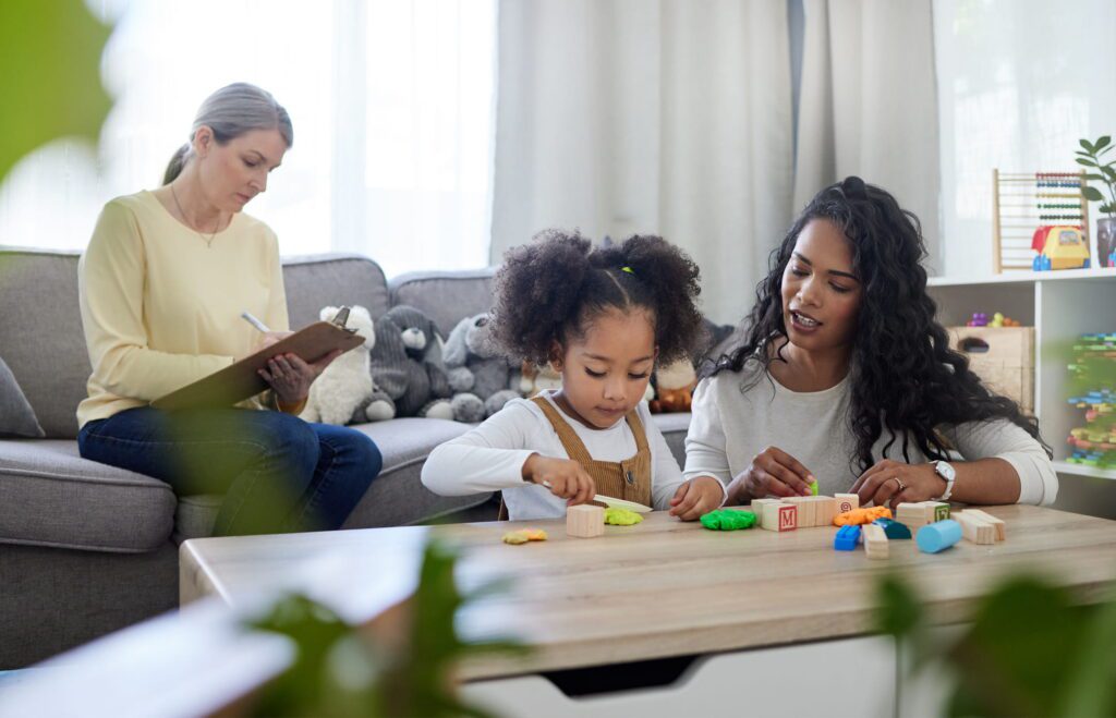 Shot of a mature therapist observing how a young mother interacts with her daughter