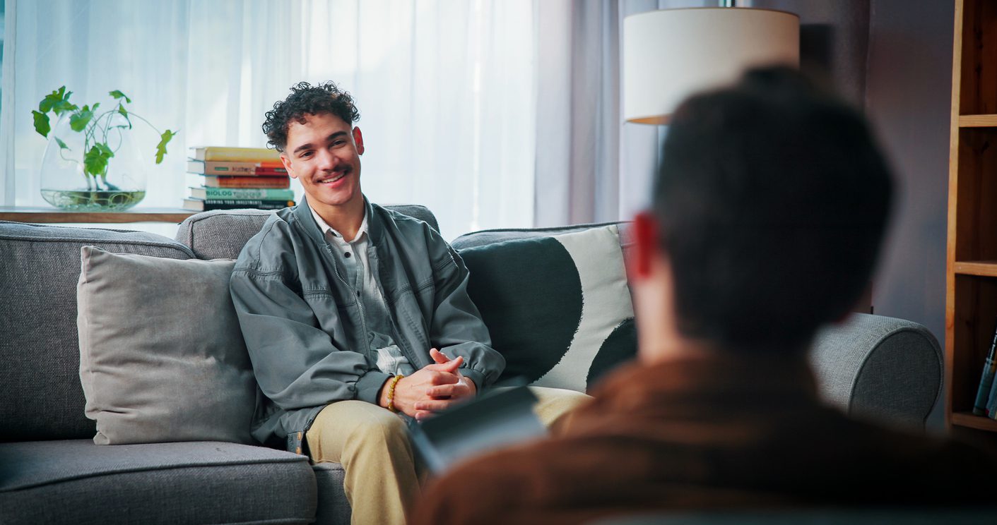 Happy man, therapy and listen to psychologist for help, support or advice with addiction recovery.